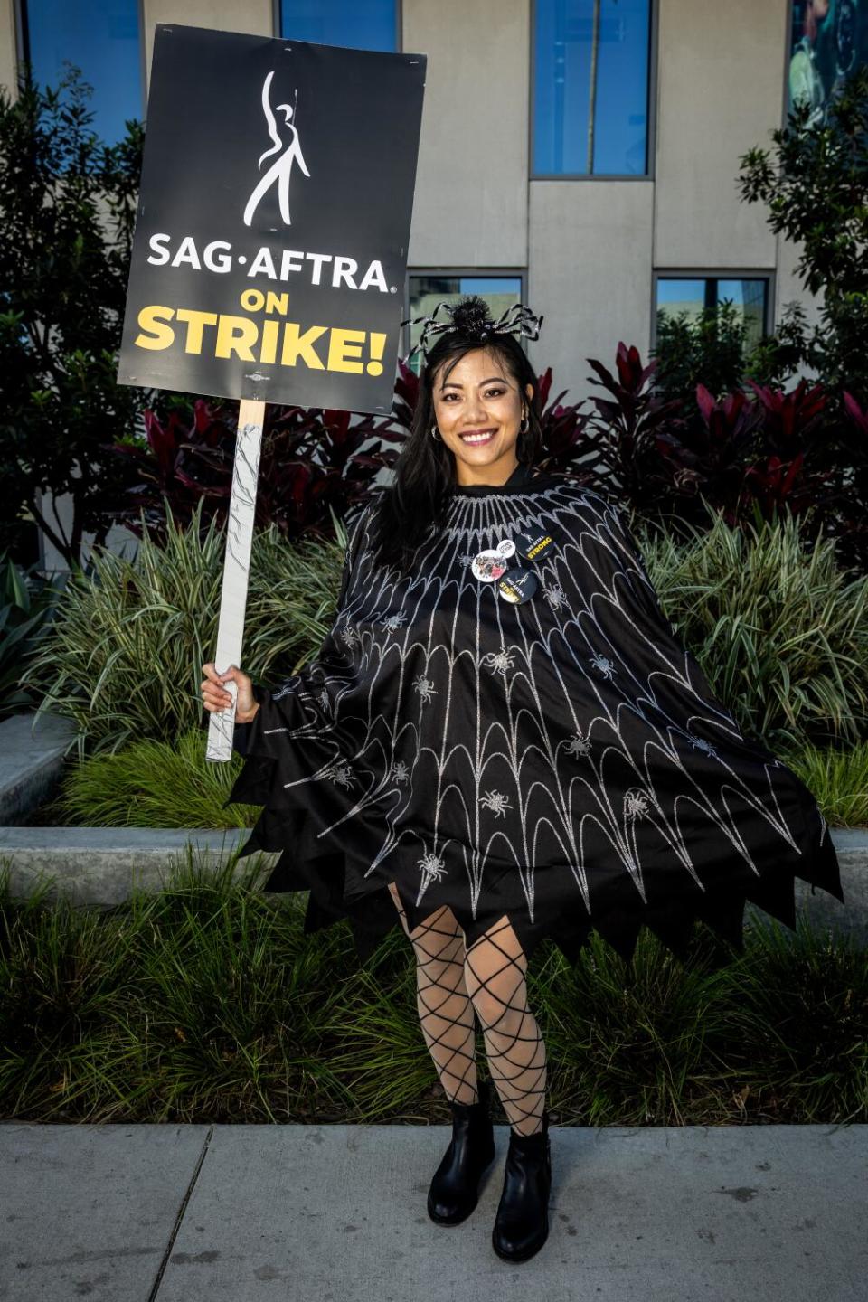 Joyce Federik, a strike captain dressed as a black spider and cobweb.