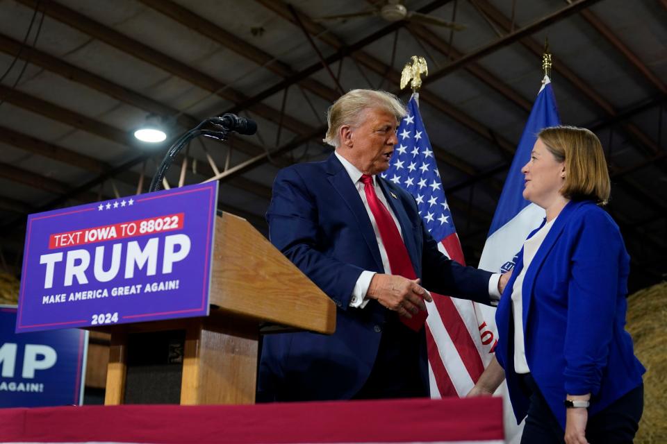 Former President Donald Trump talks with Iowa Attorney General Brenna Bird during a commit to caucus rally, Monday, Oct. 16, 2023, in Adel, Iowa. (AP Photo/Charlie Neibergall)