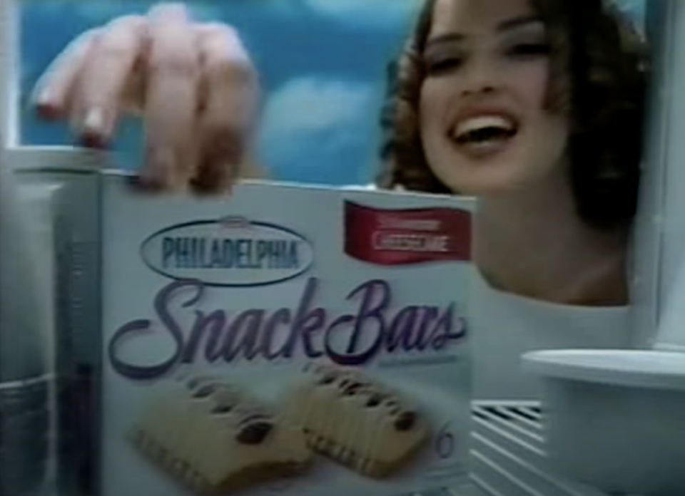 Screenshot of Snack Bar commercial, with an angel reaching into the fridge for Snack Bars