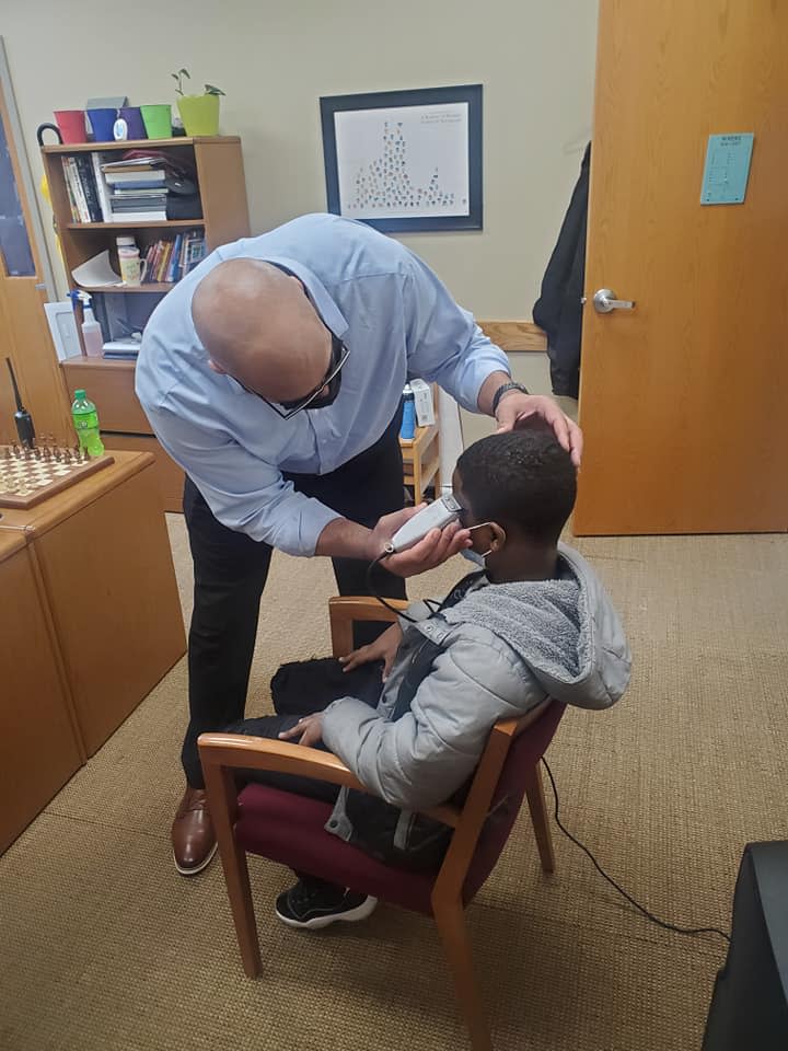 Jason Smith, the principal at Stonybrook Intermediate and Middle School, cuts a student's hair Feb. 18, 2021.