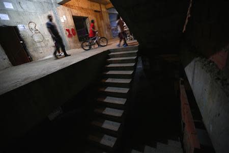 People walk along a corridor on the 10th floor of the "Tower of David" skyscraper in Caracas February 6, 2014. REUTERS/Jorge Silva