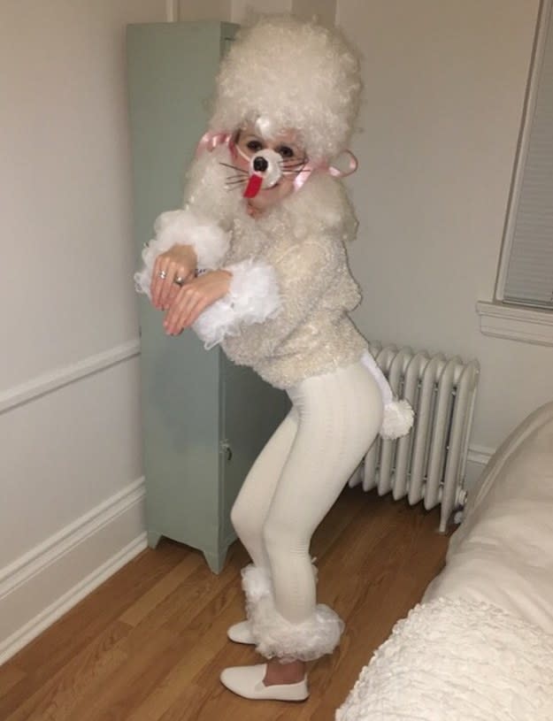 Someone covered in white fake fur with a dog face painted on themself