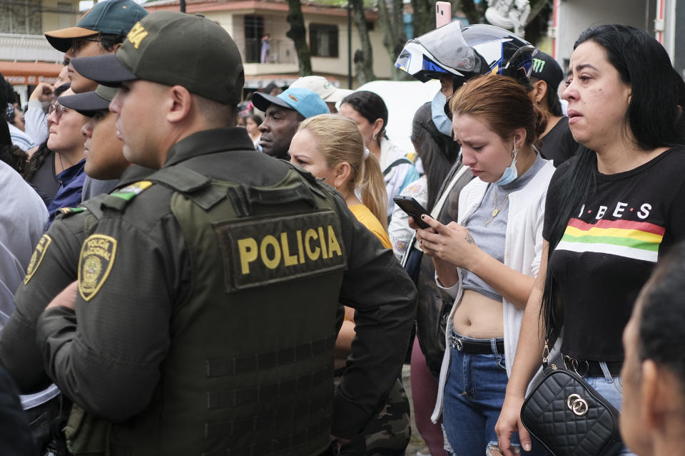 Relatives listen to a police officer reading a list of surviving inmates after a fatal fire at a jail in Tulua, Colombia, Tuesday, June 28, 2022. Authorities say at least 49 people were killed after the fire broke out during what appeared to be an attempted riot early Tuesday. (AP Photo/Juan Jose Horta)