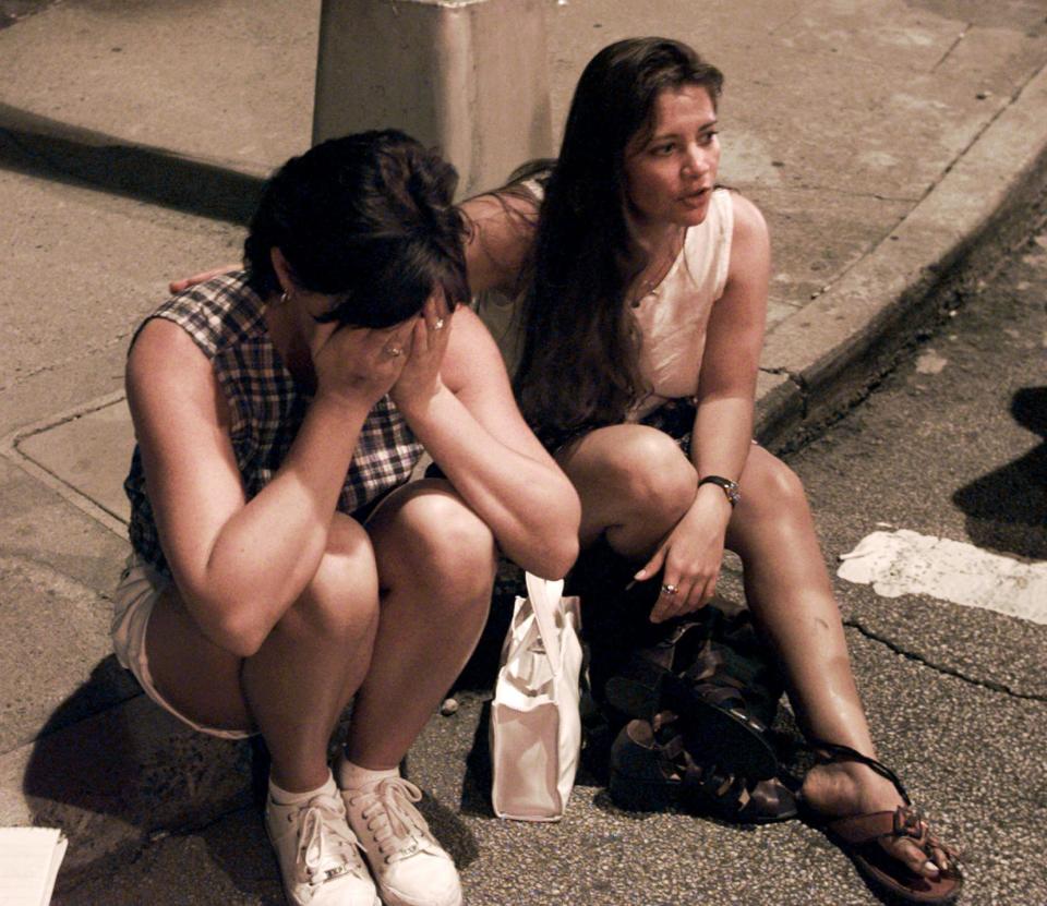 FILE - In this Saturday, July 27, 1996, file photo, Shelly Martin of Spokane, Wash., left, and Roselia Norwood of Hawaii react after an explosion occurred in Centennial Park in Atlanta during the 1996 Summer Olympics. (AP Photo/Doug Mills, File)