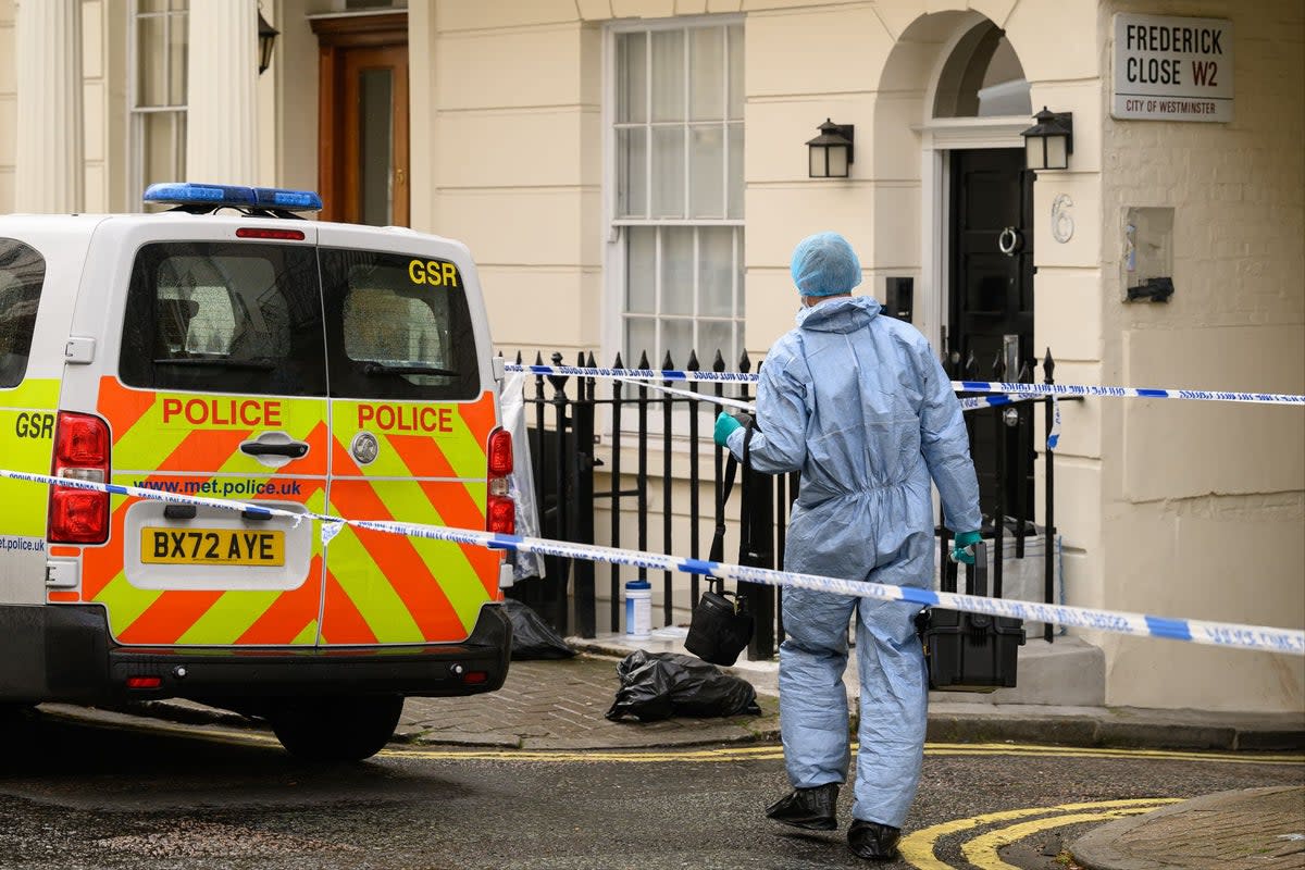 A member of the forensic search team is seen outside a residence following the discovery of a woman's body the previous day (Getty Images)