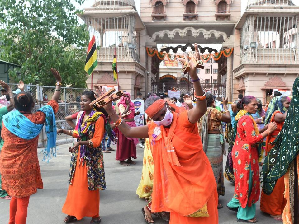 Hindu devotees dance outside Lord Jagannath Temple as the annual Rath Yatra procession was cancelled amid concerns over the spread of the COVID-19 coronavirus, in Ahmedabad on June 23, 2020. (Photo by SAM PANTHAKY / AFP) (Photo by SAM PANTHAKY/AFP via Getty Images)