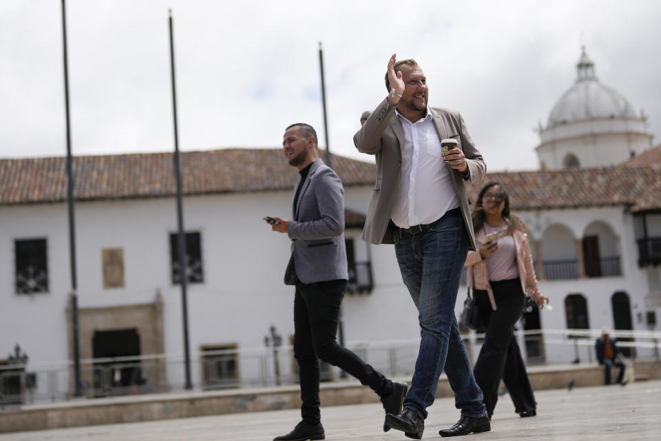 El alcalde electo Mikhail Krasnov saluda a un partidario mientras camina por la Plaza Bolívar en Tunja, Colombia, el lunes 11 de diciembre de 2023. (AP Foto/Fernando Vergara)