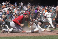 Cincinnati Reds catcher Tyler Stephenson, left, tags out San Francisco Giants' Curt Casali at home during the fifth inning of a baseball game in San Francisco, Wednesday, April 14, 2021. (AP Photo/Jeff Chiu)