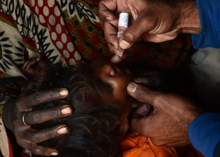 A Pakistani polio vaccination worker gives polio vaccine drops to a young child in a slum area of Lahore on December 21, 2012. Pakistan is providing paramilitary and police support to polio vaccinations being resumed discreetly in the northwest after a series of attacks on medical workers, officials said Friday