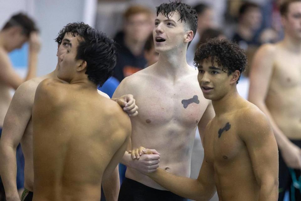 Members of the Paul Laurence Dunbar record-breaking 400-meter freestyle relay, including Alex Ochsenbein, center, and Seneca Oddo, right, look at their time after competing in the event at the Region 8 swim meet at Stivers Aquatic Center at Union College in Barbourville, Ky., on Saturday, Feb. 4, 2023.