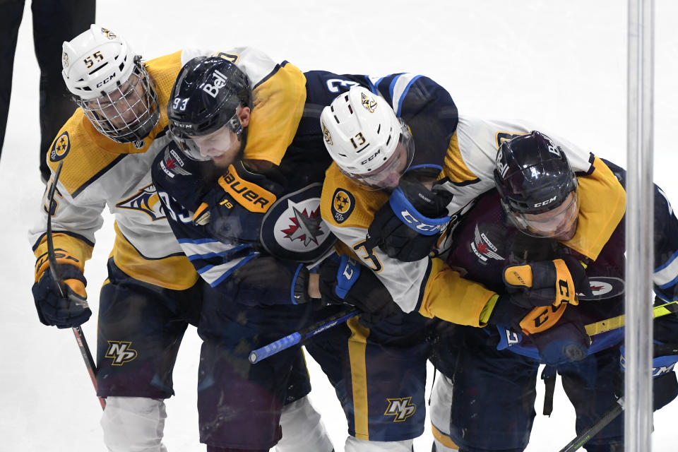 Winnipeg Jets' Kristian Vesalainen (93) and Neal Pionk (4) battle with Nashville Predators' Philippe Myers (55) and Yakov Trenin (13) during the second period of NHL hockey game action in Winnipeg, Manitoba, Saturday, Oct. 23, 2021. (Fred Greenslade/The Canadian Press via AP)