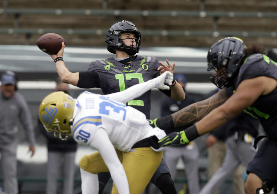 Oregon's Tyler Shough throws down field under pressure from UCLA's Elisha Guidry during the second quarter of an NCAA college football game Saturday, Nov. 21, 2020, in Eugene, Ore. (AP Photo/Chris Pietsch)