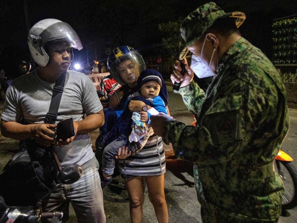 Filipino soldier checks a motorists at a checkpoint as authorities begin implementing a lockdown on Manila on March 15, 2020 in the outskirts of Metro Manila, Philippines.