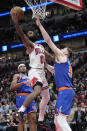 Chicago Bulls guard Coby White, left, drives to the basket against New York Knicks center Isaiah Hartenstein during the second half of an NBA basketball game in Chicago, Tuesday, April 9, 2024. (AP Photo/Nam Y. Huh)
