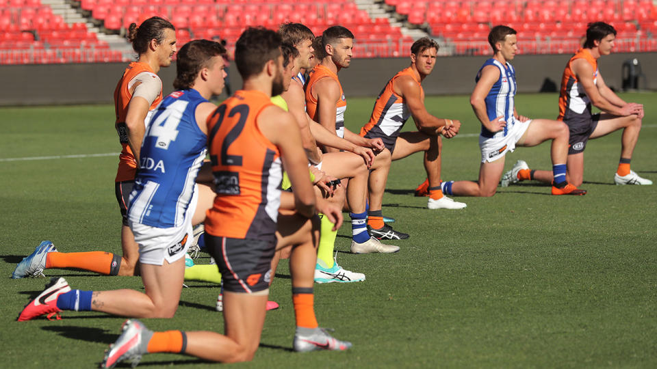 Players, coaches and umpires, pictured here taking a knee before GWS' clash with North Melbourne.