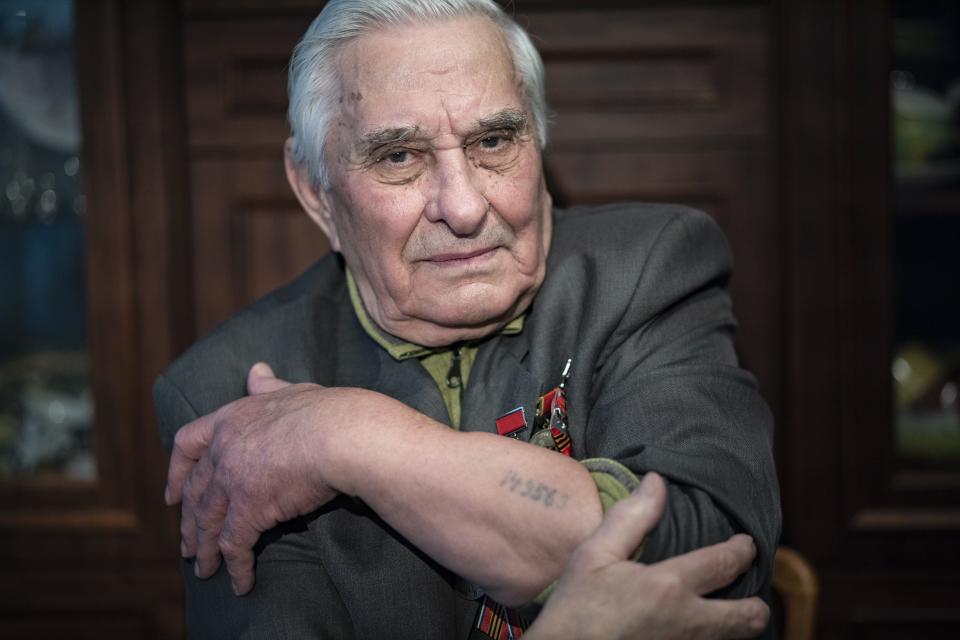 In this photo taken on Monday, Jan. 20, 2020, Yevgeny Kovalev, one of the Auschwitz concentration camp's survivors, shows the camp's identification number tattooed on his arm, during an interview with the Associated Press at his flat in Moscow, Russia. Kovalev was arrested by the Nazis as a teenager and sent to the Auschwitz death camp is still amazed 75 years later that he survived the ordeal. The 92-year-old was speaking ahead of the 75th anniversary on Monday, Jan. 27, 2020 of the camp's liberation in 1945. (AP Photo/Alexander Zemlianichenko)