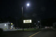 A Dollar General store sign is illuminated along a street in Zanesville, Ohio, on Sunday, July 26, 2020. Often, the most crowded parking lots are at the ubiquitous Dollar General and Family Dollar stores, signposts of financial hardship. (AP Photo/Wong Maye-E)