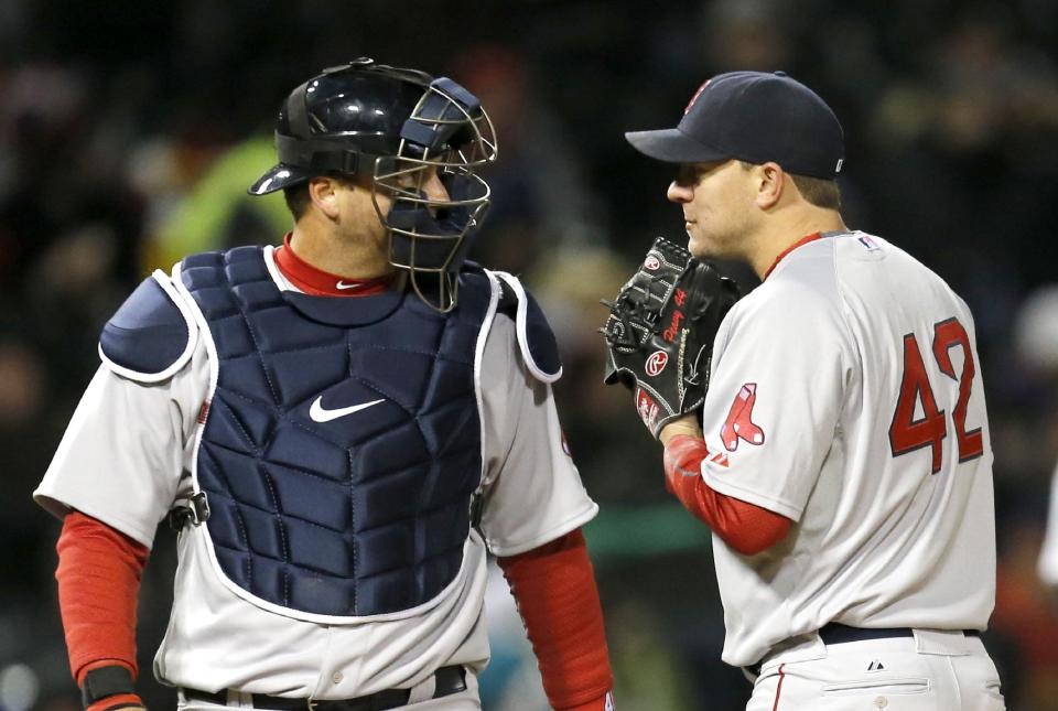 Boston Red Sox catcher A.J. Pierzynski, left, talks with starting pitcher Jake Peavy during the sixth inning of a baseball game against their former teammates, the Chicago White Sox, on Tuesday, April 15, 2014, in Chicago. (AP Photo/Charles Rex Arbogast)