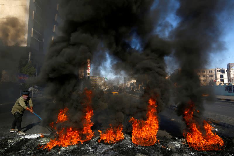 A man burns tires during ongoing anti-government protests in Najaf