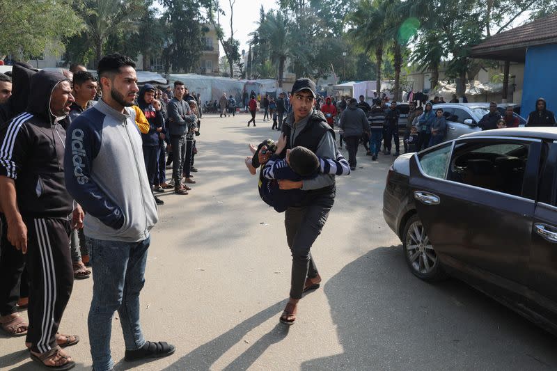 Un palestino lleva a un niño herido en un ataque israelí, en el Hospital Europeo, en Jan Yunis