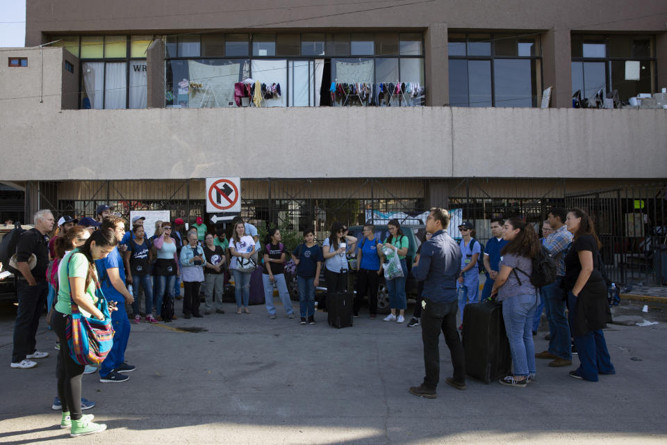 In this Oct. 26, 2019, photo, University of California San Diego medical student Phil Canete, center right in dark blue shirt with glasses, addresses a group of volunteer health practitioners from Mexico and the United States before heading out to set up clinics at shelters for migrants in Tijuana, Mexico. (AP Photo/Gregory Bull)