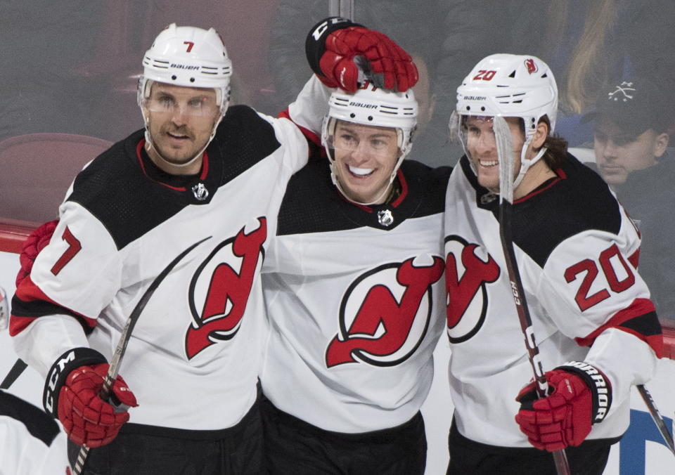 New Jersey Devils' Blake Coleman (20) celebrates with teammates Nikita Gusev and Matt Tennyson (7) after scoring against the Montreal Canadiens during first-period NHL hockey game action in Montreal, Thursday, Nov. 28, 2019. (Graham Hughes/The Canadian Press via AP)