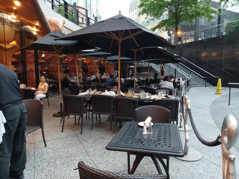 The exterior of the Cheesecake Factory in Chicago on the Magnificent Mile. The photo shows its outdoor seating