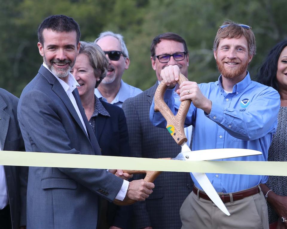 Eric Ellis, left, Great Lakes Commission project manager, and Ryan Darnton, habitat resource specialist with the Great Lakes Regional Office of the NOAA Restoration Center, cut the ribbon during Thursday's celebration.