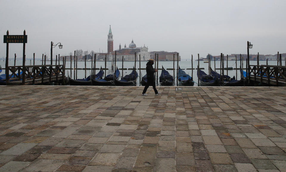 A man walks in an empty St. Mark's Square in Venice, Italy, Saturday, Jan. 30, 2021. (AP Photo/Antonio Calanni)