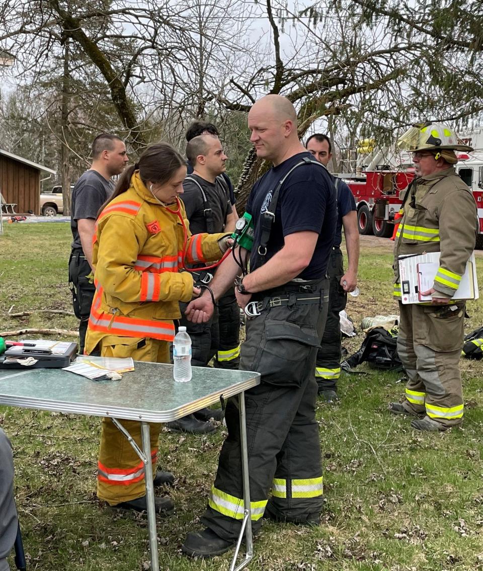 An emergency medical service member takes the blood pressure of a firefighter at the recovery station during Monday's Central Wood County Rapid Intervention Team training.