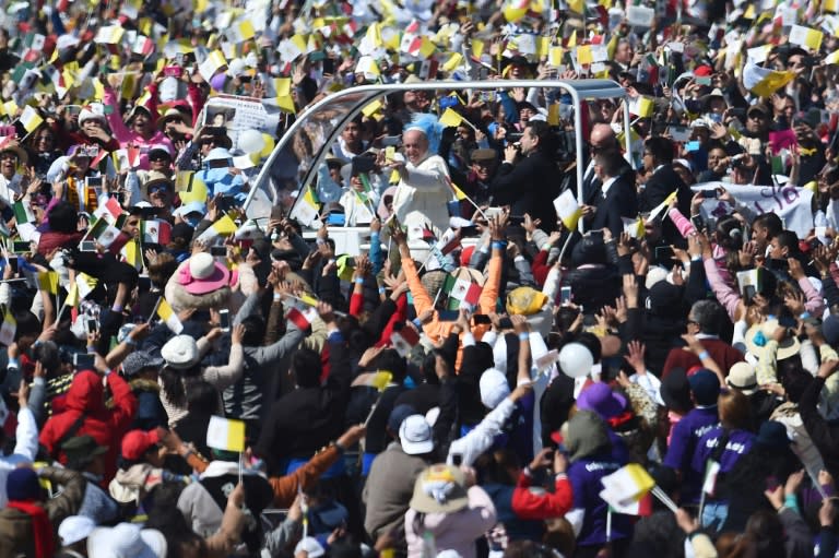 Pope Francis waves as he arrives to celebrate an open-air mass in Ecatepec --a rough, crime-plagued Mexico City suburb-- on February 14, 2016