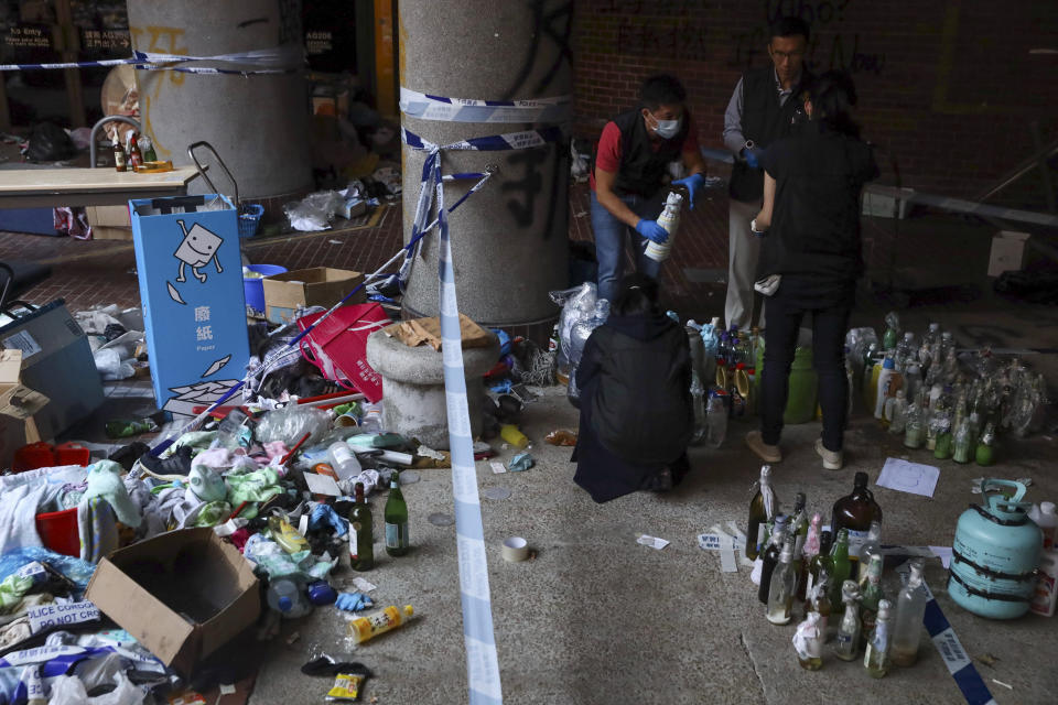 Police collect molotov cocktails and flammable materials used by protesters as evidence in a cordoned off area on the Polytechnic University campus in Hong Kong, Thursday, Nov. 28, 2019. Police safety teams Thursday began clearing the university that was a flashpoint for clashes with protesters, and an officer said any holdouts still hiding inside would not be immediately arrested. (AP Photo/Ng Han Guan)