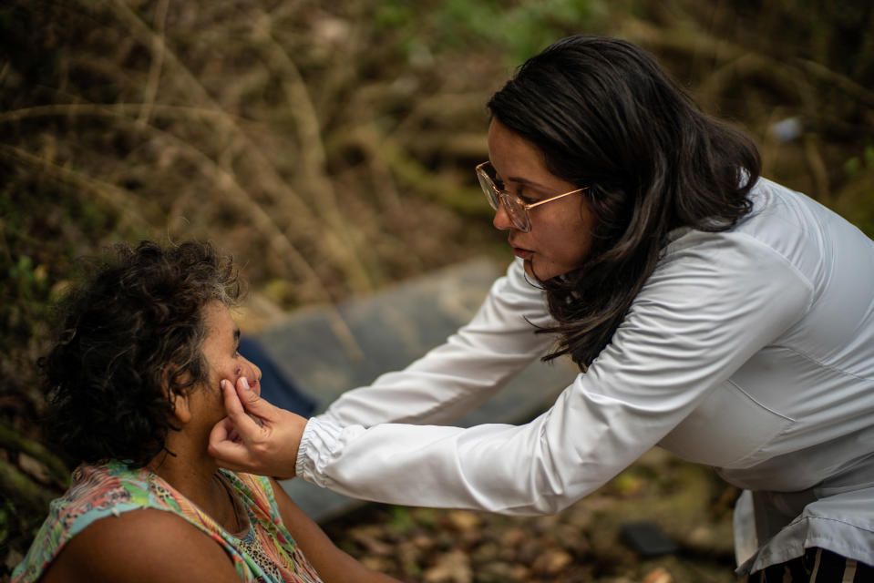 Juliana Quintero le aplica al leñador Luis Alfonso Tilano una crema desarrollada en la localidad para tratar la leishmaniasis, una enfermedad causada por parásitos, en Medellín, Colombia, el 21 de enero de 2023. (Federico Rios/The New York Times).