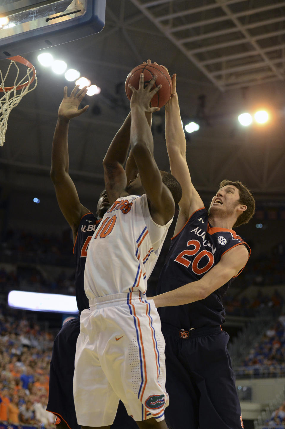 Auburn forward Alex Thompson (20) gets a hand on the ball to keep Florida forward Dorian Finney-Smith (10) from making his shot during the first half of an NCAA college basketball game Wednesday Feb. 19, 2014 in Gainesville, Fla. (AP Photo/Phil Sandlin)