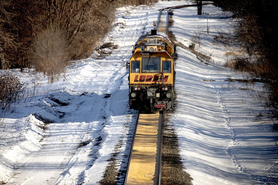 A train makes its way along a path where corn spilled from a train on a Canadian Pacific line and sat two inches deep for just under a half-mile, Tuesday, January 7, 2020 in Crystal, Minn. (Elizabeth Flores/Star Tribune via AP)