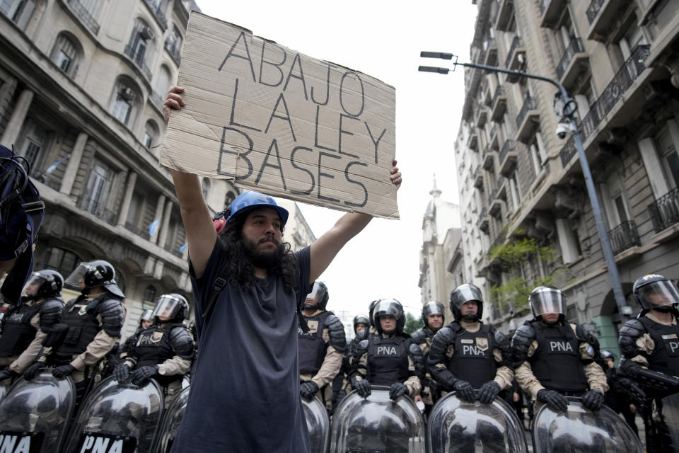 Un manifestante contra el gobierno con un cartel contra una reforma impulsada por el presidente argentino, Javier Milei, a las fueras del Congreso frente a la policía, en Buenos Aires, Argentina, el miércoles 12 de junio de 2024. (AP Foto/Natacha Pisarenko)