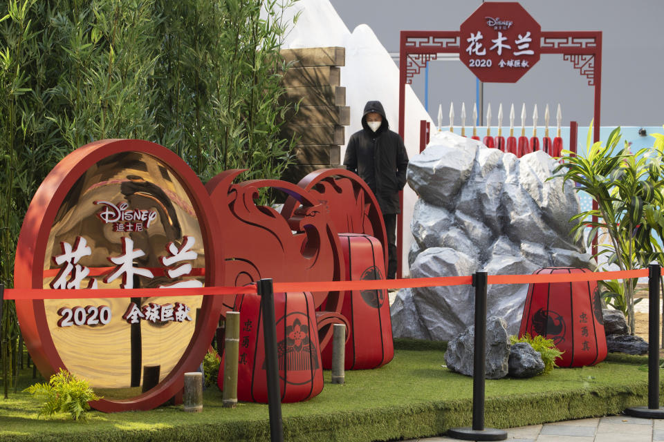 A man watches over a set promoting the Disney movie "Mulan" in Beijing on Wednesday, Feb. 19, 2020. Disney is under fire for filming part of its live-action reboot “Mulan” in Xinjiang, the region in China where the government has been accused of human rights abuses against Uighurs and other predominantly Muslim minorities. (AP Photo/Ng Han Guan)