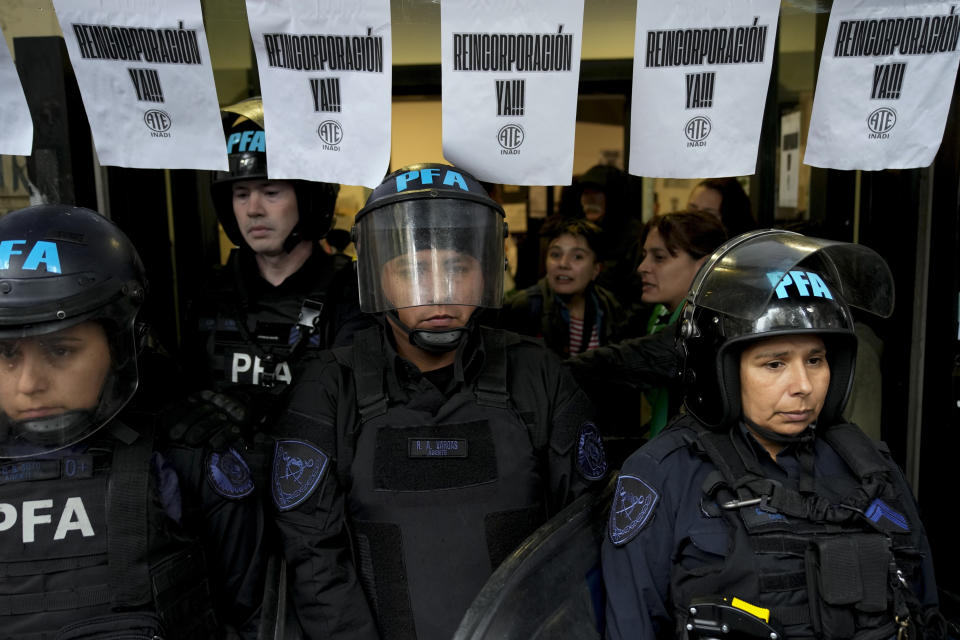 La policía hace guardia fuera del Instituto Nacional contra la Discriminación, la Xenofobia y el Racismo (INADI) para impedir la entrada de trabajadores que fueron despedidos en Buenos Aires, Argentina, el miércoles 3 de abril de 2024. En sus primeros cuatro meses al poder, el presidente ultraliberal Javier Milei degradó el Ministerio de Mujeres, Géneros y Diversidad al rango de subsecretaría, prohibió el uso del lenguaje inclusivo en la administración pública y cerró el INADI. (AP Foto/Natacha Pisarenko)