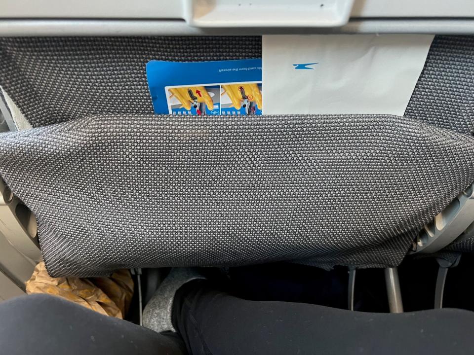 The seatback pocket with papers in it.