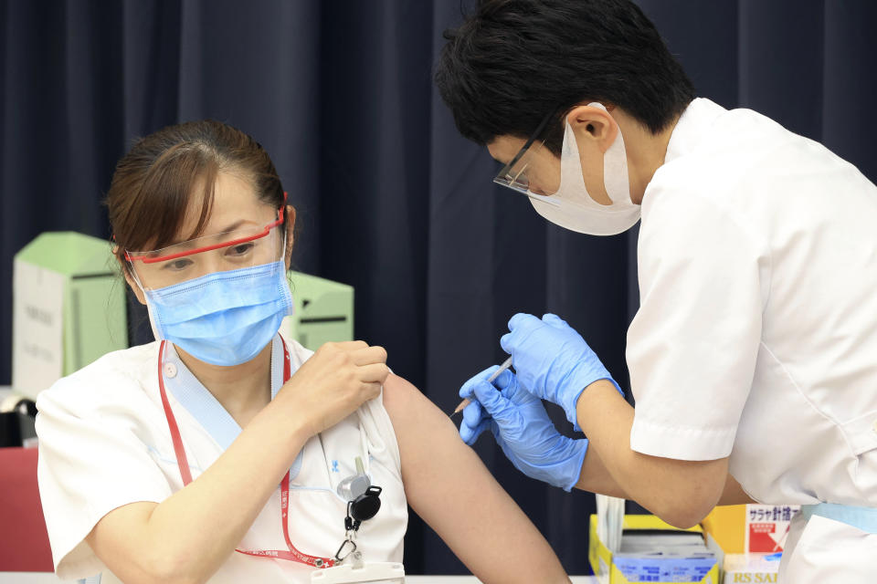 A medical worker receives doses of a Pfizer COVID-19 vaccine at the Tokyo Metropolitan Cancer and Infectious Diseases Center Komagome Hospital in Tokyo on March 5, 2021. Japan's government will extend a state of emergency in the Tokyo region for another two weeks because its medical systems are still strained by COVID-19 patients, the minister in charge of virus response said Friday. (Yoshikazu Tsuno/Pool Photo via AP)