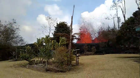 Lava is seen from a fissure appearing behind a resident's backyard in Puna, Hawaii, U.S. in this still frame taken from May 6, 2018 video obtained from social media. KEITH BROCK/Social Media via REUTERS