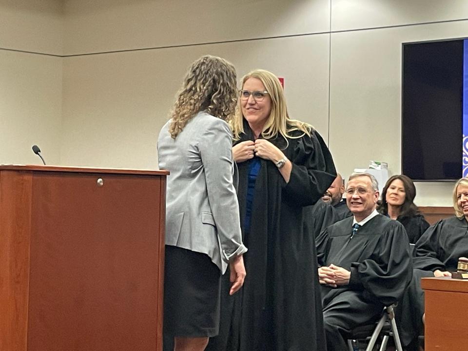 County Judge Lori Cotton puts on her robe given to her by Assistant State Attorney and President of the Marion County Bar Association Wynn Vickers, at Cotton's investiture on Friday at the Marion County Judicial Center.