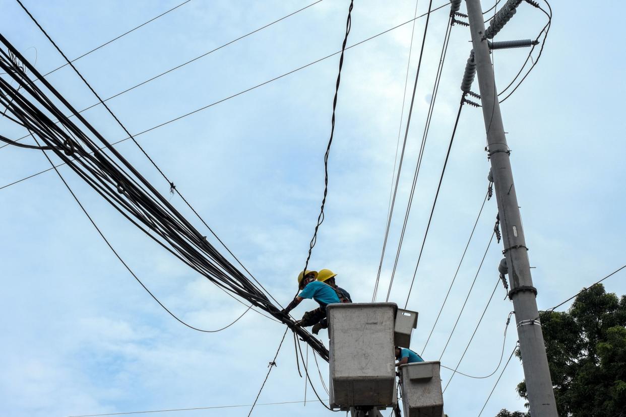 Manila Electric Co. (Meralco) workers repair damaged power lines in Quezon City, Metro Manila, the Philippines, on Thursday, July 28, 2022. The Philippines gets about 57% of its electricity from coal, burning the equivalent of 29 million tons of high quality fuel, according to data from BloombergNEF and BP Plc. Photographer: Veejay Villafranca/Bloomberg