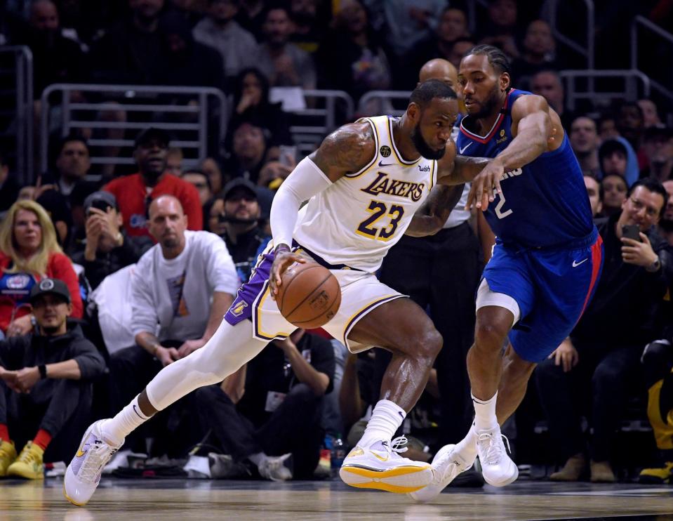 Lakers' LeBron James drives to the basket on Clippers' Kawhi Leonard during the first half at Staples Center on March 8.