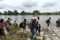 Honduran migrants prepare to board makeshift rafts to cross the Suchiate River on the border between Guatemala and Mexico in Ciudad Tecun Uman, Guatemala