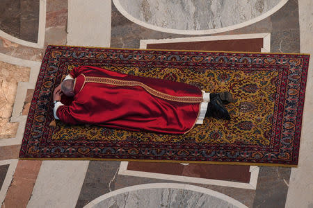 Pope Francis lies on the ground to pray during the Celebration of the Lord's Passion on Good Friday in Saint Peter's Basilica at the Vatican, April 19, 2019. Tiziana Fabi/Pool via Reuters