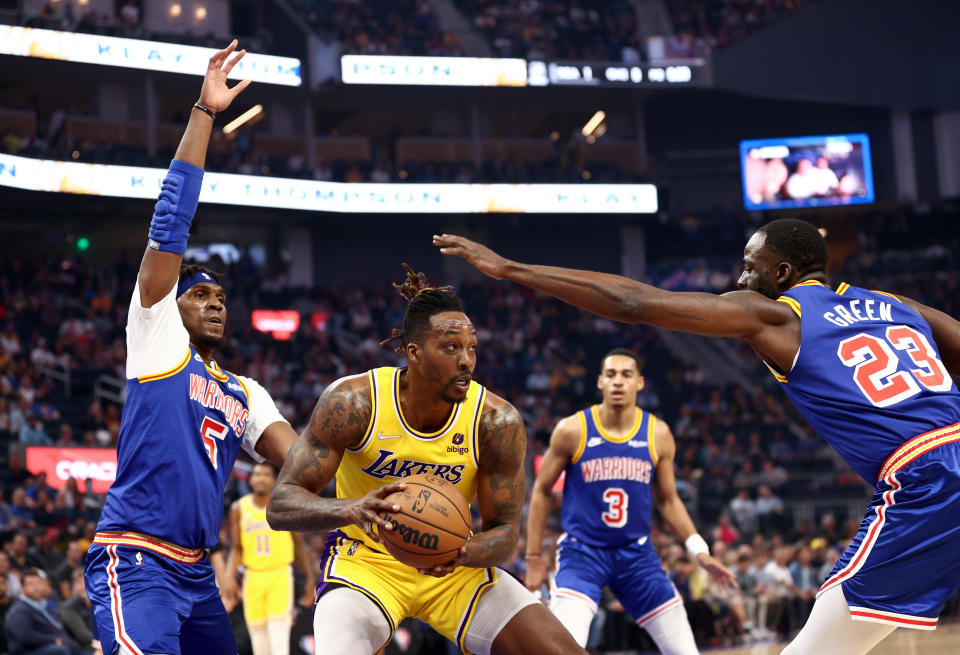 Dwight Howard #39 of the Los Angeles Lakers is guarded by Kevon Looney #5 and Draymond Green #23 of the Golden State Warriors in the first half at Chase Center on April 07, 2022 in San Francisco, California.