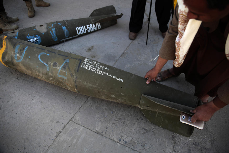 FILE - In this Oct. 5, 2016 file photo, a Yemeni man displays an American-made CBU 58A/B, cluster bomb, in a police compound in Sanaa, Yemen. The Saudis are keen buyers of American weapons, using them in the Yemen War. The Trump administration says a proposed $110 billion deal would bolster the U.S. economy by creating tens of thousands of jobs and they do not want to risk that contract. But with Saudi writer Jamal Khashoggi feared dead, some want that transaction revisited. (AP Photo/Hani Mohammed)