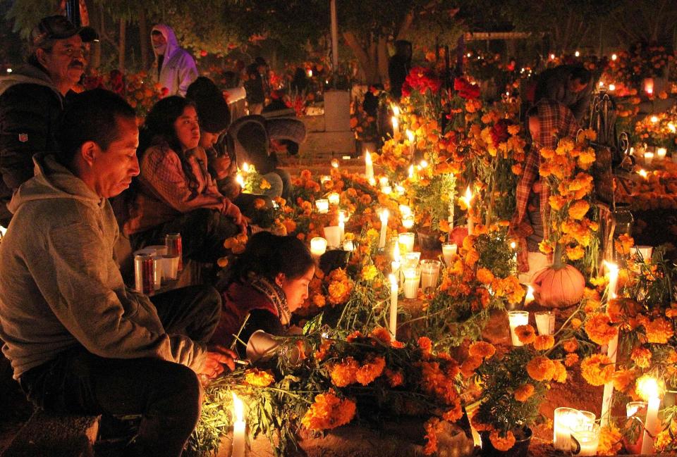 People attend the cemetery during the celebration of the Day of the Dead in Santa Maria Atzompa, Oaxaca state, Mexico, on November 1, 2022.