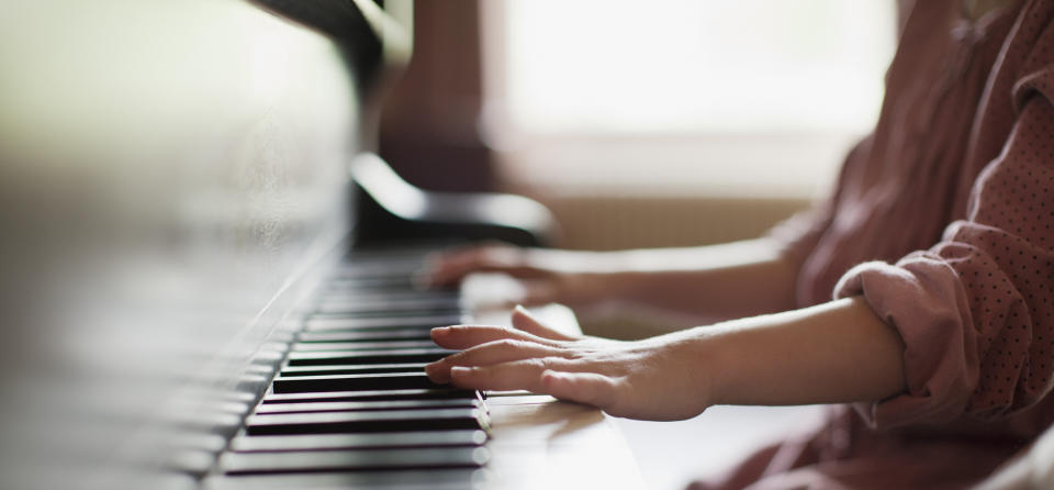 Child's hands on piano keys, practicing